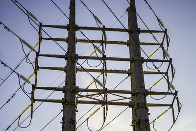 Low angle view of electricity pylon against sky