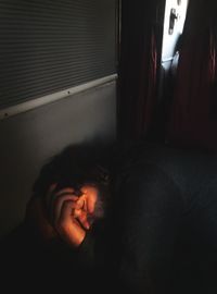 Close-up of man relaxing on bed at home