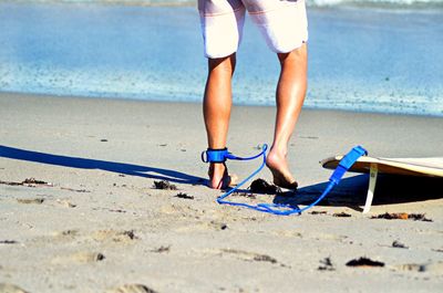 Low section of a surfer on beach