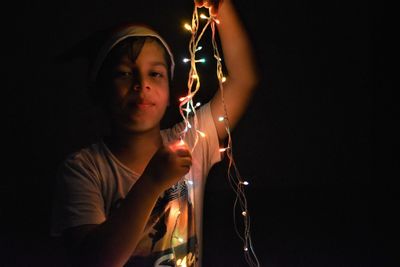 Portrait of girl holding illuminated lighting equipment