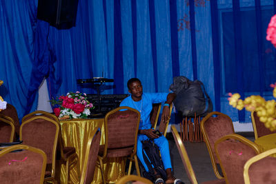 Rear view of woman sitting on chairs