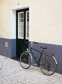 Bicycle parked against wall of building