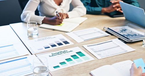 Midsection of business people working at desk in office
