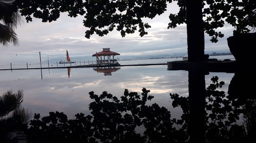 Silhouette of trees against cloudy sky