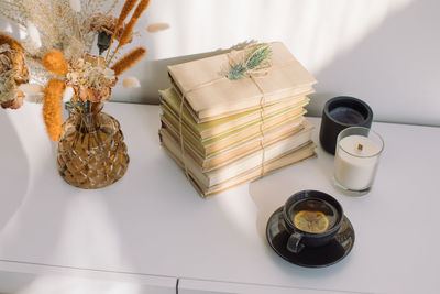 High angle view of lemon tea by stack of books on table