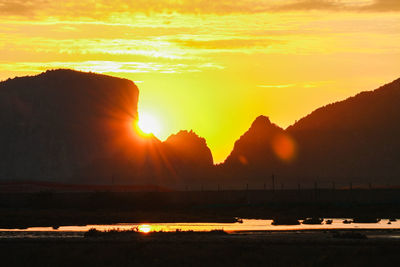 Scenic view of silhouette mountains against sky during sunset