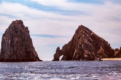 Rock formations by sea against sky