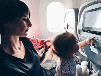 Rear view of women sitting in airplane