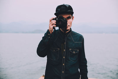 Man photographing from camera by sea