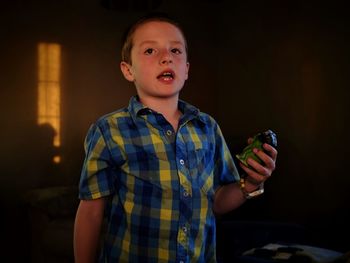 Boy holding toy animal at home