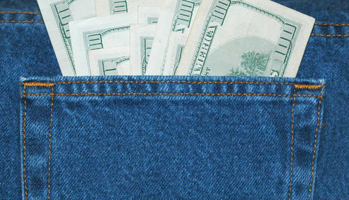 Close-up of paper currencies in jeans pocket