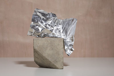 Decorative composition with cubic stone and crumpled aluminum foil