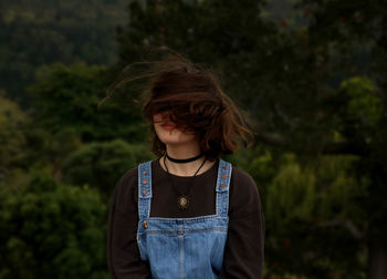 Woman standing against trees