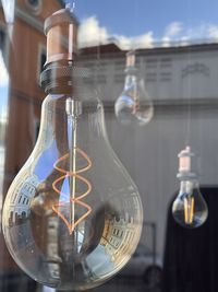 Close-up of light bulb and reflection of houses 