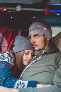 Couple embracing while sitting in car during winter