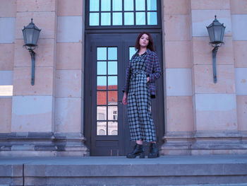 Full length of woman standing against building