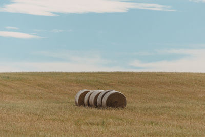 Hay bales on field against sky