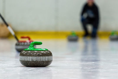 Low section of man playing curling on ice rink