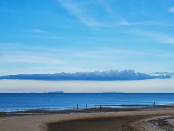 Scenic view of beach against blue sky