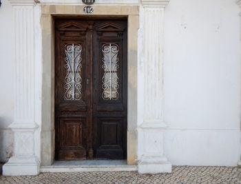 Old wooden door on a white painted facade