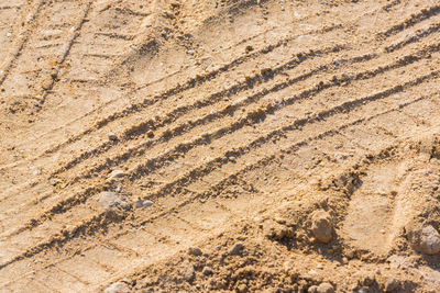 High angle view of tire tracks on sand