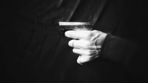 Close-up of hand holding light against wall