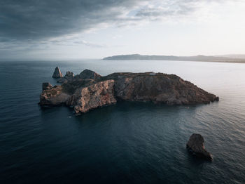 Rock formation in sea against sky