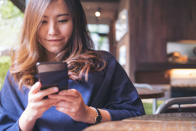 Woman using phone at cafe