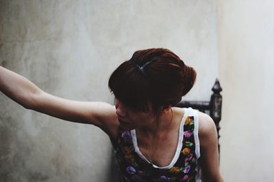 Close-up of woman by wall