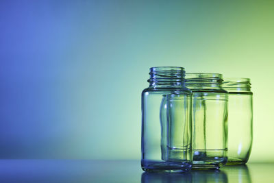 Close-up of glass jar on table against blue background