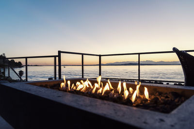 Fire pit by ocean during sunset