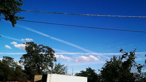 Low angle view of power lines against blue sky