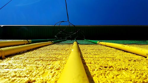 Surface level of railroad tracks against clear blue sky