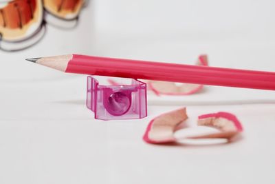 Close-up of pencil and sharpener over white background