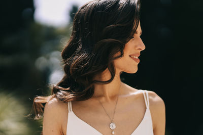 Portrait of smiling young woman looking away outdoors