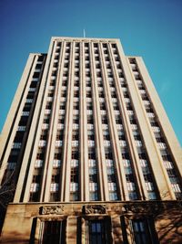 Low angle view of modern building against clear blue sky