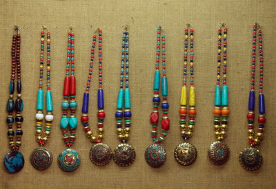 Close-up of colorful necklace hanging on wall for sale