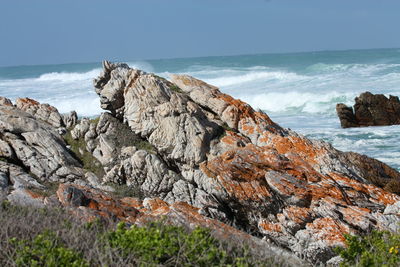 Rock formation on beach against sky