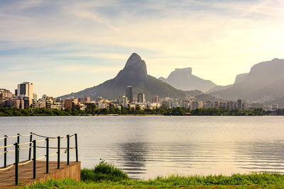 City at waterfront against cloudy sky