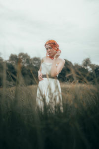 Portrait of woman standing against sky