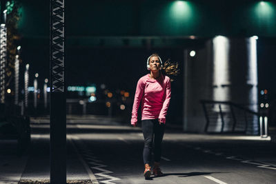 Full length of woman standing on street at night