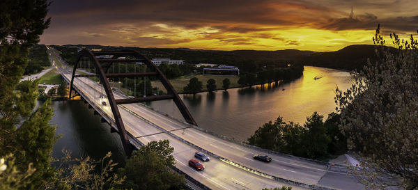 Bridge over river against sky during sunset
