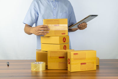 Midsection of man holding box against white background