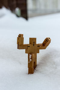 Close-up of wooden figurine on snow