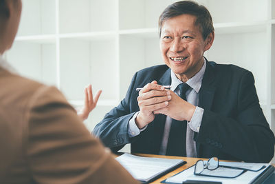 Smiling businessman having discussion with colleague in office