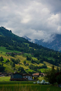 Houses by trees and mountains against sky