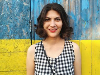 Portrait of smiling young woman against barn