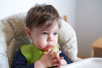 Little baby having tomatoes in the high chair