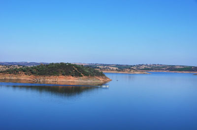 Scenic view of lake against clear blue sky