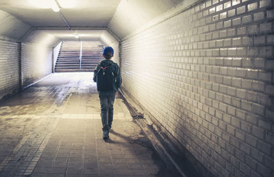 Rear view of boy walking on footpath